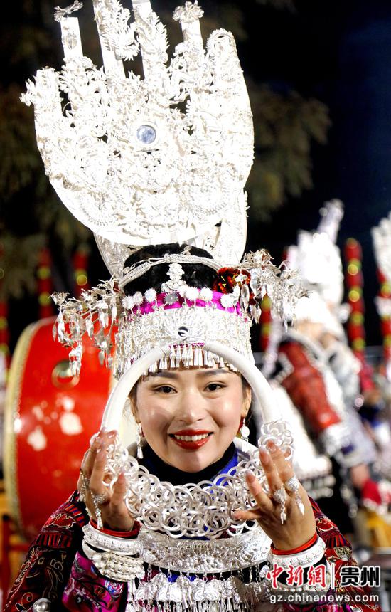 2023年12月31日晚贵州黔东南州施秉县马号镇六合村跨年晚会上一苗族女子展示自己的银项圈。  奉力 摄