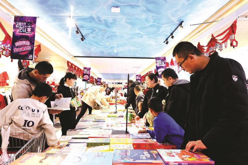 2023年12月31日，汇嘉时代昌吉购物中心负一层，昌吉市民带孩子挑选书籍。　付小芳摄

