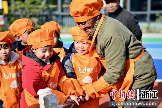 小浦幼儿园的孩子在学打年糕。殷飞摄
