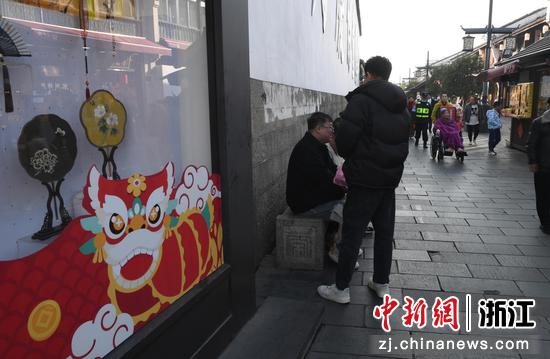 河坊街商家橱窗张贴龙元素贴纸。中新社记者 王刚 摄