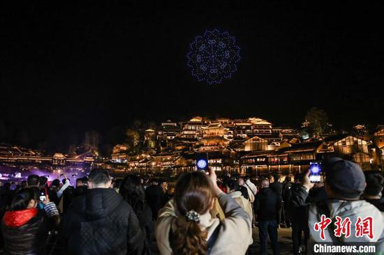 游客在拍摄乌江寨国际旅游度假区无人机编队表演。中新网记者 瞿宏伦 摄