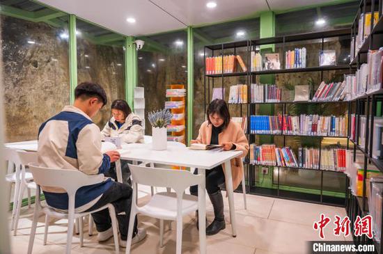 1月16日，图为游客在贵州册亨板万溶洞图书馆阅览图书。唐哲 摄