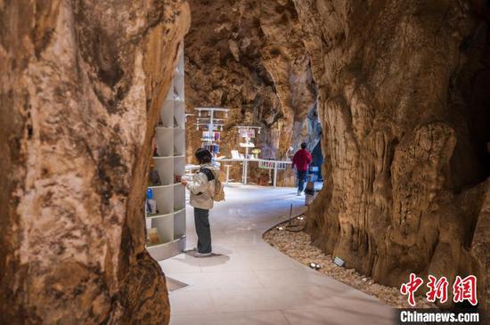 1月16日，图为游客在贵州册亨板万溶洞图书馆阅览图书。唐哲 摄