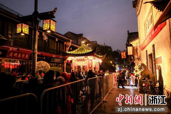 杭州市民在方回春堂河坊街馆门口排队领腊八粥。  齐文灿 摄