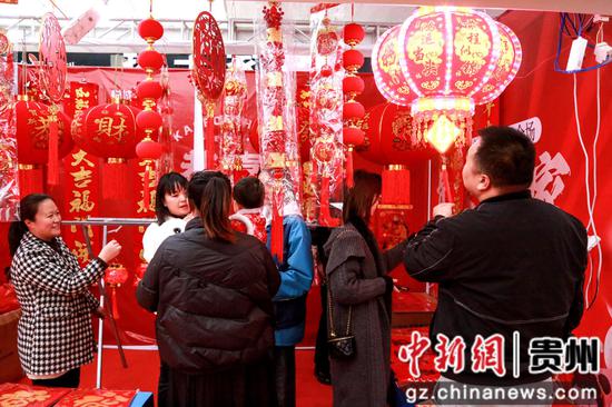 2024年1月18日，市民群众在贵州省遵义市播州区桂花桥社区悦城年货节上购买春联。