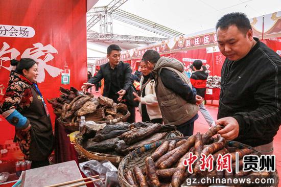 2024年1月18日，市民群众在贵州省遵义市播州区桂花桥社区悦城年货节上购买年货腊肉、香肠。