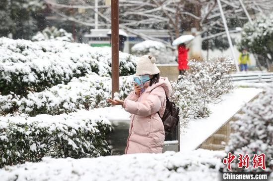 市民在贵阳市甲秀楼景区拍摄小雪人。中新网记者 瞿宏伦 摄