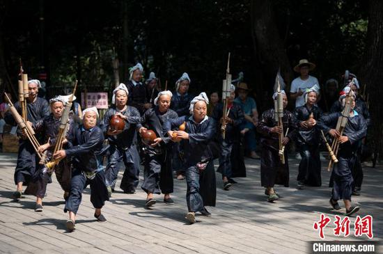 资料图：村民在贵州省从江县丙妹镇岜沙苗寨为游客表演舞蹈。吴德军 摄