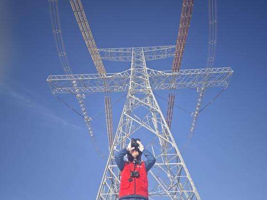 2023年12月30日，新疆送变电公司员工在±1100千伏吉泉线0421号塔开展保电特巡。赵志强 摄