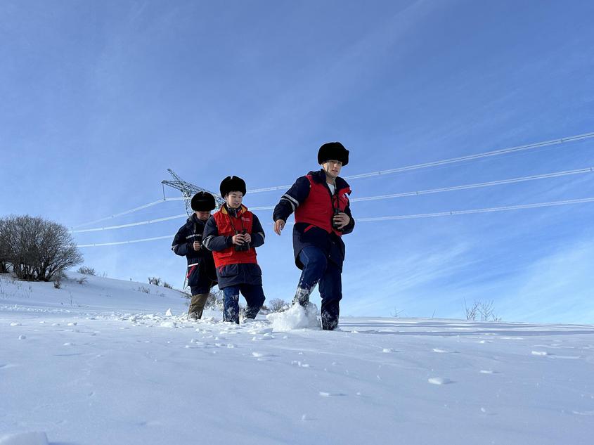 1月13日，新疆送变电公司员工在750千伏赛伊二线88号塔开展迎峰度冬保电特巡。李晶晶 摄
