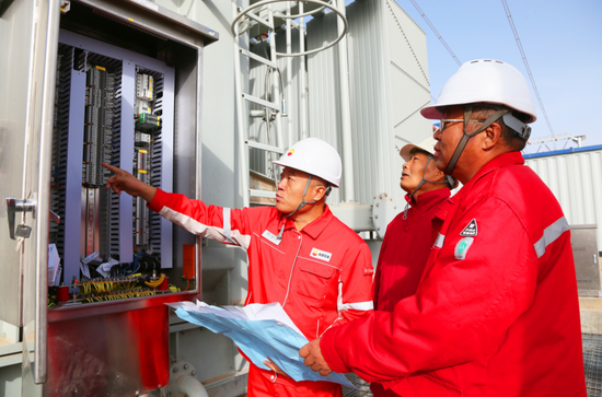 塔里木石油人在光伏发电站的升压区检查设备运行情况。陈士兵 摄