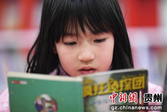 1月26日，一名小学生正在贵阳市南明区图书馆内的少儿阅读区阅读儿童图书。