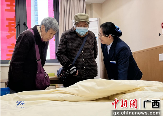  图为广旅集团幸福旅程康养中心工作人员向受邀老人介绍该中心住宿环境许丽媛 摄