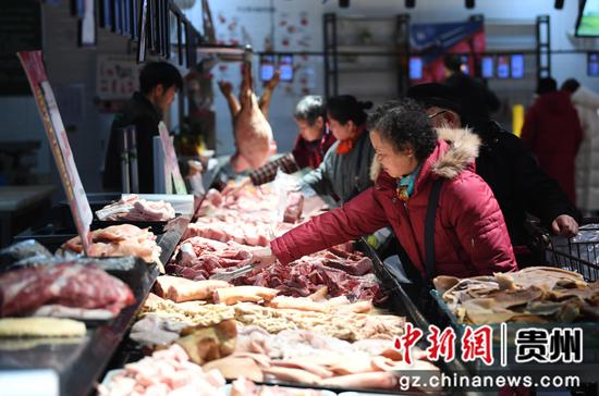 1月26日，市民在贵阳市南明区合力超市花果园R区店内选购猪肉。