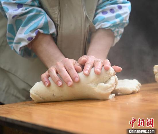 图为村民在揉搓米豆腐。谢慧芳 摄