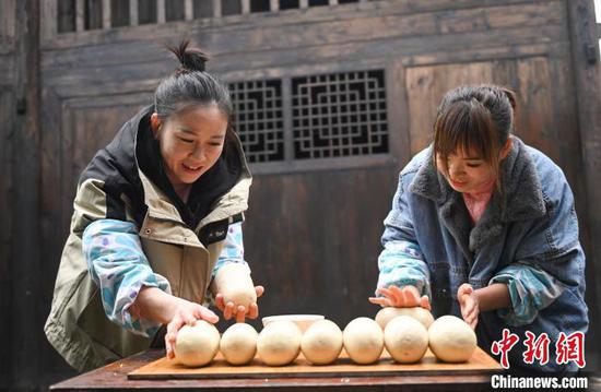 图为村民在揉搓米豆腐。谢慧芳 摄