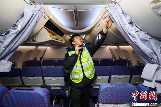 图为机务人员在安装飞机发动机降温设备。中新网记者 瞿宏伦 摄