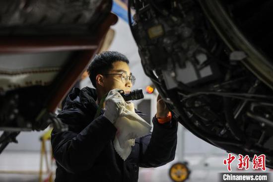 图为机务人员在检修飞机发动机。中新网记者 瞿宏伦 摄