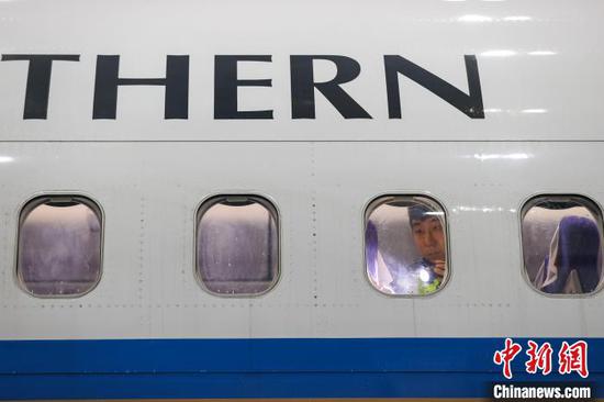 图为一名机务在检查飞机客舱设备。中新网记者 瞿宏伦 摄