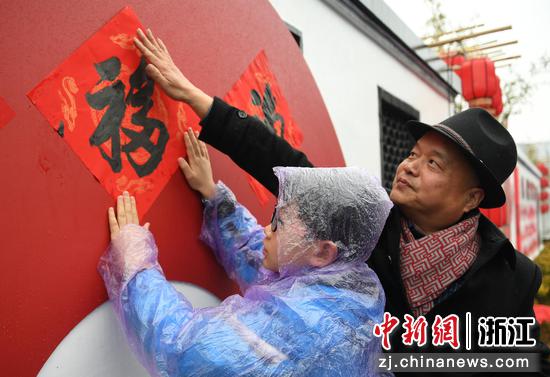 市民将写好的福字贴在墙上。中新社记者 王刚 摄