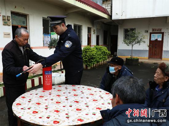 图为1月31日，民警在给老人讲解灭火器的使用方法。