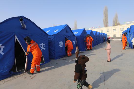 1月25日，国网乌什县供电公司应急基干队员在乌什县第三大队临时居民安置点检查帐篷用电情况。马海骄 摄