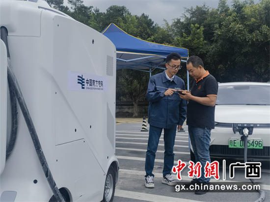 在G80广昆高速容县服务区，工作人员指引帮助返乡民众使用移动充电车充电。董申颂 摄