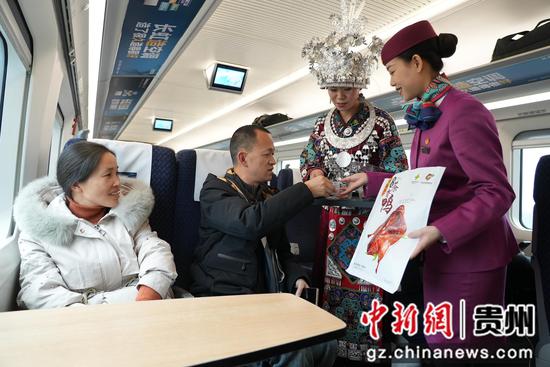 列车工作人员邀请旅客试吃都匀毛尖茶香鸭。李儒鑫 摄