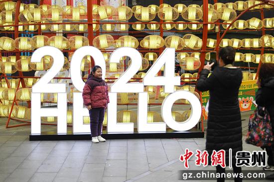 2月7日，在青云路步行街“2024百姓新春年货节”现场，一位小朋友正在2024新年灯光背景前拍照打卡。