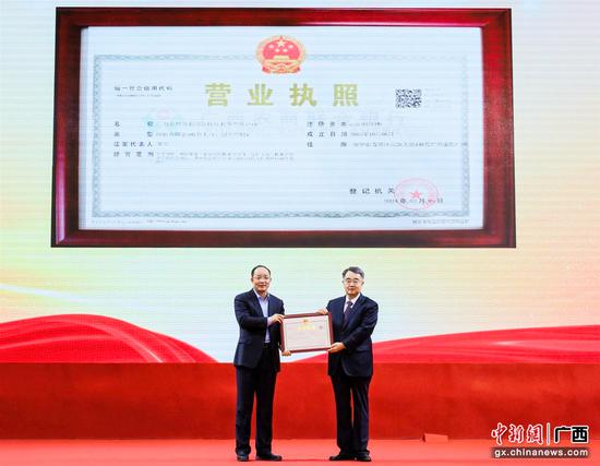 广西市场监督管理局局长李泽向广西农商联合银行颁发营业执照。