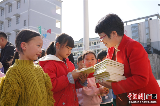 图为丁灯诗歌微电影、诗歌MV公益巡播到广西隆林县者浪乡中心小学给留守儿童捐书。被访者供图