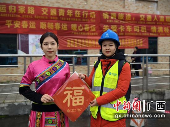 志愿者在桂林龙胜桂三高速收费站为返乡民众送春联。