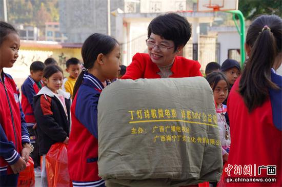 图为丁灯给广西隆林县播立村小学的学生捐赠棉被。被访者供图