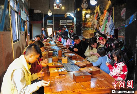游客在贵州省从江县高增乡非遗传承基地体验侗族刺绣。卢忠南 摄