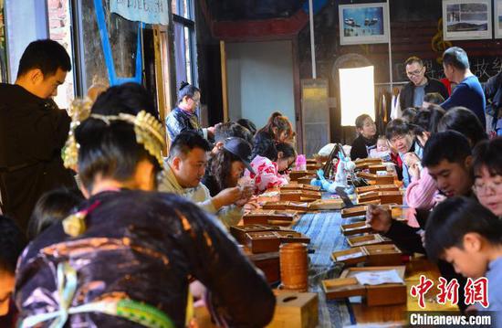 游客在贵州省从江县高增乡非遗传承基地体验侗族刺绣。卢忠南 摄