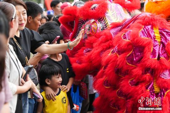 当地时间2月18日，第二十届菲中传统文化节在位于菲律宾马尼拉的黎刹公园中国园举行。图为中国舞狮表演吸引当地民众。中新社记者 张兴龙 摄