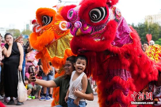 当地时间2月18日，第二十届菲中传统文化节在位于菲律宾马尼拉的黎刹公园中国园举行。图为观众与中国舞狮合影。中新社记者 张兴龙 摄