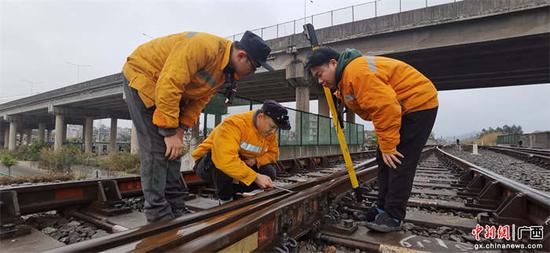 玉林工务段职工正在使用直尺检测线路钢轨道岔接头高低、方向、水平等几何尺寸和线路钢轨平顺度。李慕传  摄.