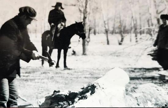 上世纪80年代，马殿英（左）在额尔齐斯河畔帮助牧民收集过冬柴火（资料图片）。十师北屯市党委宣传部提供