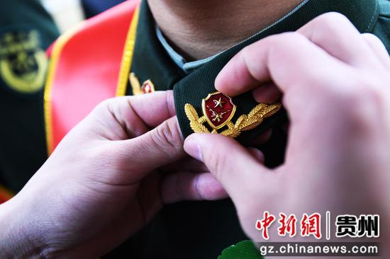 2月29日，武警贵阳支队南明中队战士为退伍老兵卸下领花。