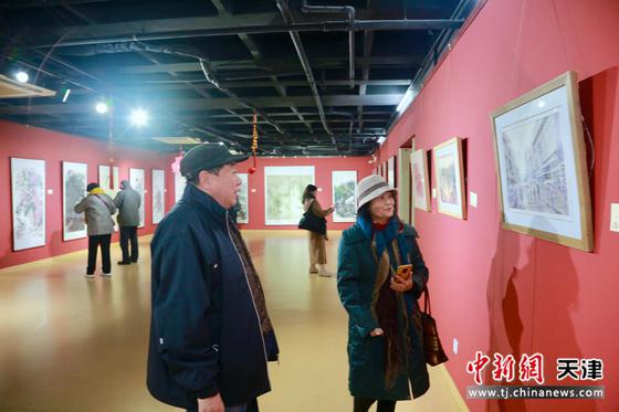 天津水彩女画家田同芬（右一）在展览现场介绍作品。刘俊苍 摄