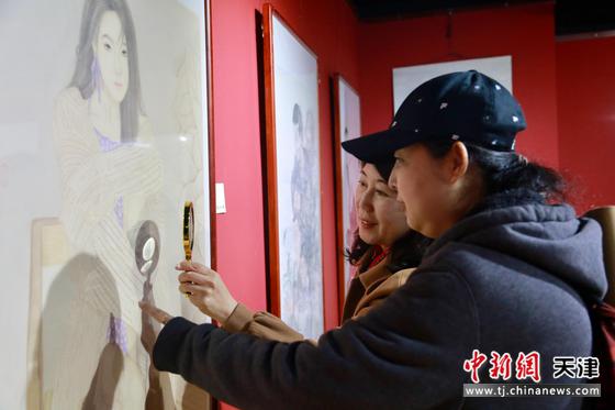 天津女画家陈艳梅（左一）在展览现场介绍作品。刘俊苍 摄