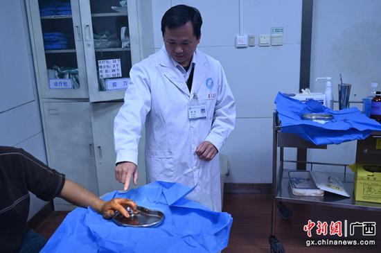 梧州市中医医院急诊科副主任曾昭看望蛇伤者康复情况。