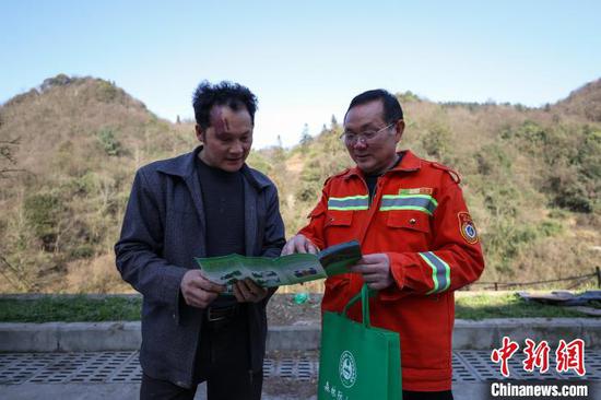 3月11日，陈正华(右)在给村民普及森林防火注意要点。中新网记者 瞿宏伦 摄
