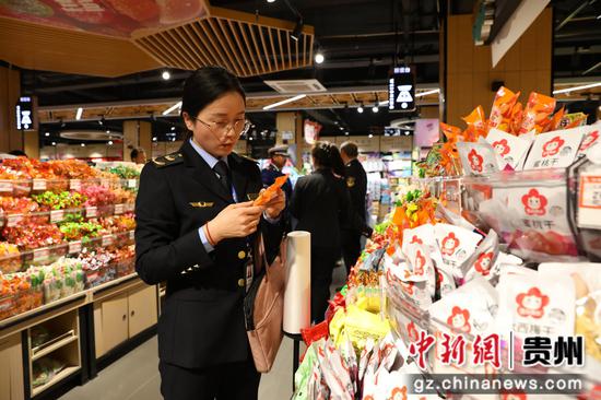 图为剑河县市场监督管理局工作人员正在超市零食区检查。杨洁茹摄