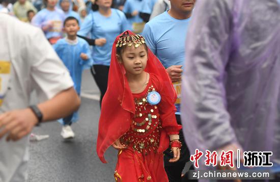 小朋友身穿特色服饰参加马拉松。中新社记者 王刚 摄