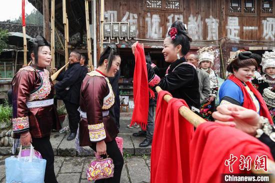 小丹江苗寨村民在“招龙节”现场拦门迎宾。中新网记者 瞿宏伦 摄
