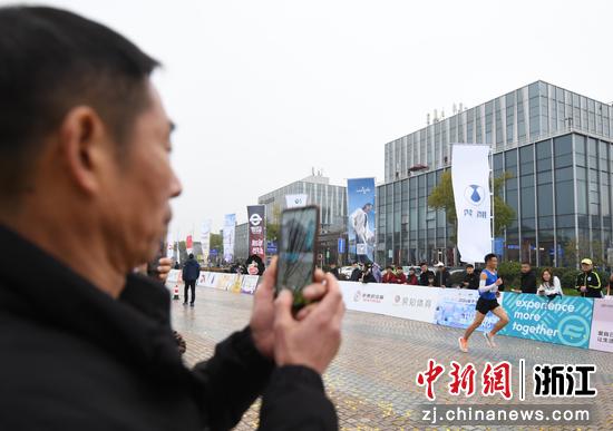 市民拍摄马拉松跑者。中新社记者 王刚 摄