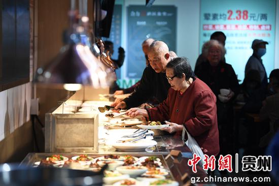 3月19日，居民正在贵阳市南明区合力超市南浦路店幸福大食堂取餐。