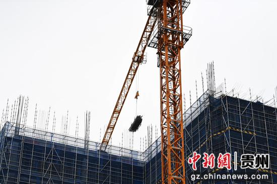 3月20日，在贵阳市南明绿色制造产业园配套基础设施及营业性用房项目建设现场，贵州建工十一建的工人正在吊运施工建材。